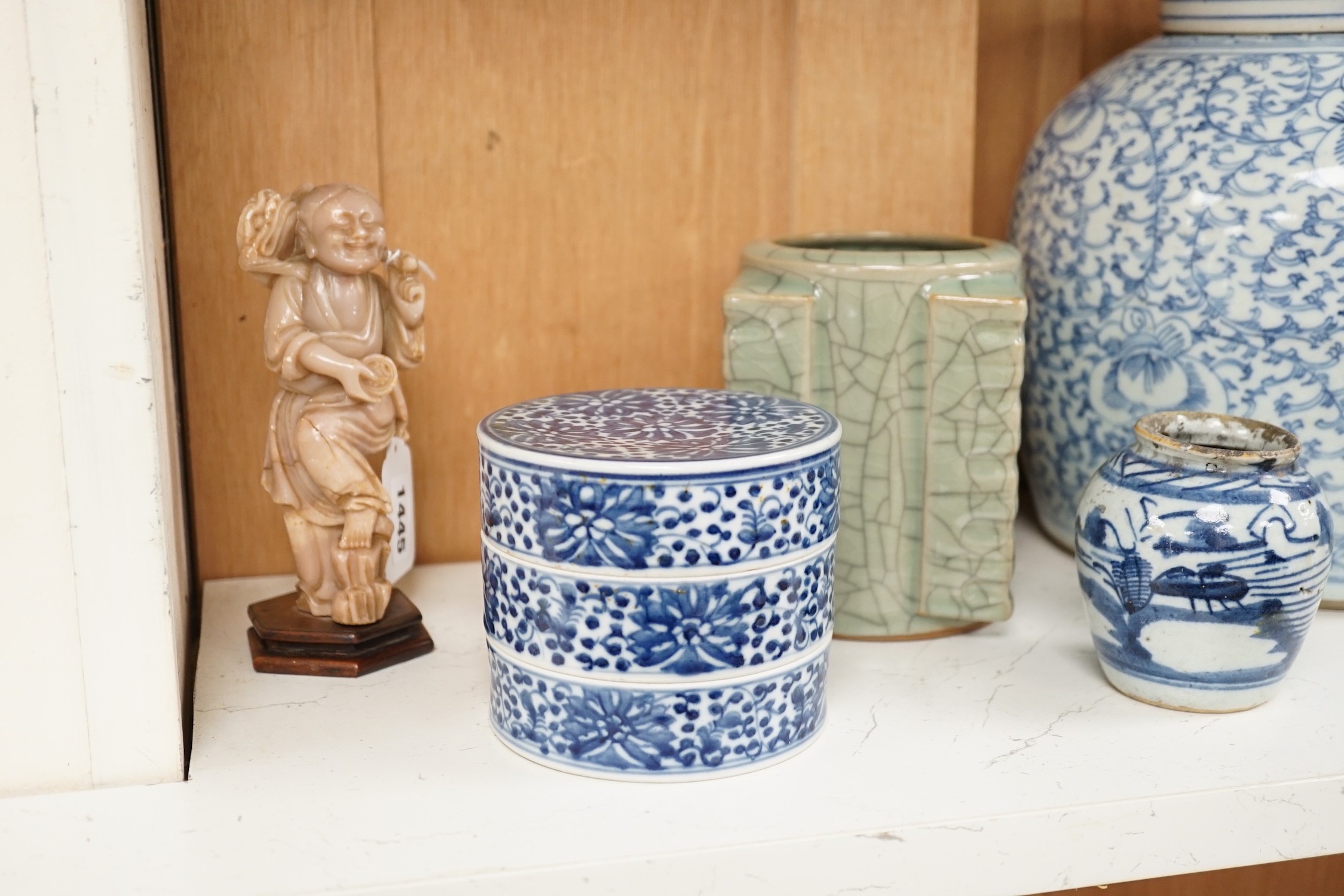A group of 19th century blue and white jars, a stacking food box and two bowls, together with a celadon glazed cong vase and a soapstone figure of Liu Hai. Tallest 24cm